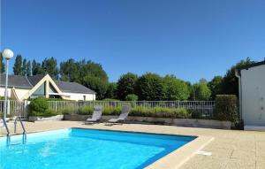 a swimming pool with two chairs and a fence at Maison 4 in Montmartin-sur-Mer