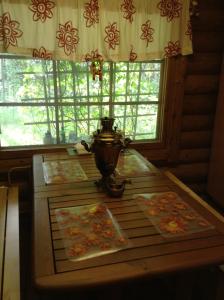a table with a tea pot on it in front of a window at Unien Koti Cottage in Mattila