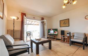 a living room with a couch and a tv at Lovely Home In Roquebrune-sur-argens With Kitchen in Saint-Peïre-sur-Mer