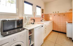 a kitchen with a washing machine and a sink at Awesome Home In Roquebrune-Sur-Argens in Saint-Peïre-sur-Mer