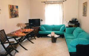 a living room with a blue couch and a table at Nice Home In Agia Marina Aigina With Kitchen in Agia Marina Aegina
