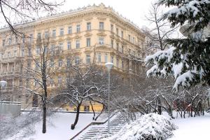 ein großes Gebäude mit Schnee auf dem Boden davor in der Unterkunft Royal Prague Apartment Celakovskeho Sady in Prag
