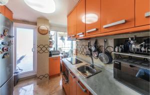プラヤ・デアロにあるStunning Apartment In Platja Daro With 3 Bedrooms And Wifiのキッチン(オレンジ色のキャビネット、シンク付)