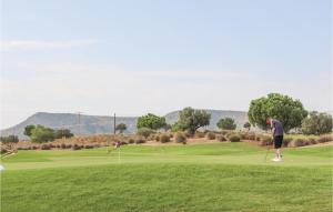 een man speelt golf op een golfbaan bij Hacienda Riquelme in Sucina