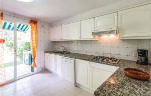 a kitchen with white cabinets and a counter top at Nice Home In Sant Feliu De Guíxols in Sant Feliu de Guixols