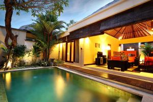 a house with a swimming pool in front of a house at The Bali Bliss Villa in Seminyak