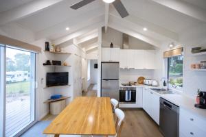 a kitchen with a wooden table and a large window at Lakeview Retreat Metung in Metung