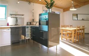 a kitchen with a refrigerator and a table with chairs at Three-Bedroom Holiday Home In St Michel En L'herm in Saint-Michel-en-lʼHerm