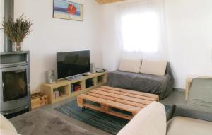 a living room with a couch and a tv at Three-Bedroom Holiday Home In St Michel En L'herm in Saint-Michel-en-lʼHerm