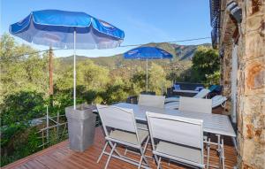 a table with chairs and an umbrella on a deck at Stunning Apartment In Partinello With 3 Bedrooms And Wifi in Partinello