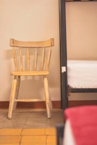 メデジンにあるCasa Estación Hostal y Restauranteの二段ベッドの横に木製椅子