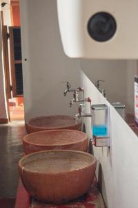 una fila di tre lavandini marroni in bagno di Casa Estación Hostal y Restaurante a Medellín