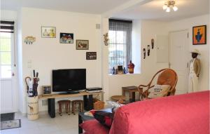 a living room with a red couch and a tv at La Maison Dici Et Dailleurs in Créances