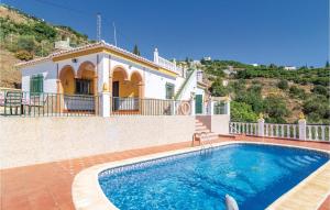 a villa with a swimming pool in front of a house at Stunning Home In Torrox With House A Mountain View in Torrox