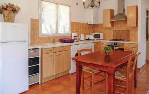 uma cozinha com uma mesa de madeira e um frigorífico branco em Gorgeous Home In Casalabriva With Wifi em Casalabriva