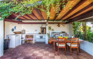 a patio with a table and chairs under a pergola at 3 Bedroom Pet Friendly Home In Trencall in Balcon del Mar