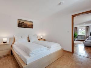 a white bedroom with a large bed with white pillows at Apartment in Malsburg Marzell with private garden in Marzell