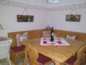 a dining room table with a bottle of wine on it at Bayerischer Rückzugsort in der Nähe des Chiemsees in Übersee