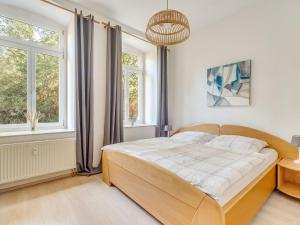 a bedroom with a large bed and two windows at Apartment with large communal terrace in Wünschendorf