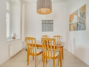 uma sala de jantar com uma mesa de madeira e cadeiras em Apartment with large communal terrace em Wünschendorf