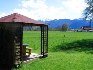 einen Pavillon mit einer Bank auf einem Feld in der Unterkunft Cosy Holiday Home in Feldwies near Ski Area in Übersee