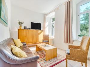 een woonkamer met een bank en een salontafel bij Apartment with large communal terrace in Wünschendorf