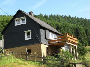 ein schwarzes Haus mit einem Balkon an der Seite in der Unterkunft Spacious holiday home in Sauerland with terrace in Glashütte