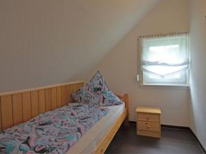 ein kleines Schlafzimmer mit einem Bett und einem Fenster in der Unterkunft Spacious holiday home in Sauerland with terrace in Glashütte