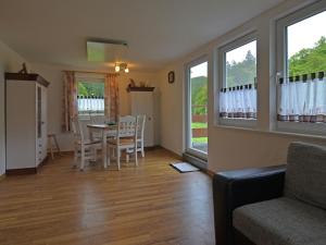 a living room with a table and chairs and windows at Spacious holiday home in Sauerland with terrace in Glashütte