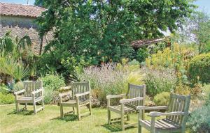 3 chaises en bois assises dans l'herbe dans un jardin dans l'établissement Amazing Home In Rioux, à Rioux