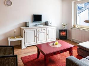 ein Wohnzimmer mit einem TV und einem Couchtisch in der Unterkunft Apartment in Brilon with a small garden in Brilon