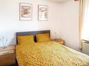 ein Schlafzimmer mit einem gelben, karierten Bett mit zwei Nachttischen in der Unterkunft Apartment in Brilon with a small garden in Brilon