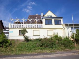 uma casa branca com uma varanda em cima em Beautiful Holidayhome with sauna and terrace em Harscheid