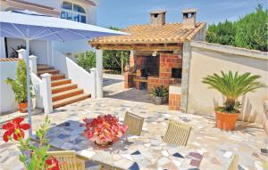 a patio with a table and an umbrella at Lovely Home In Alcúdia in Alcudia