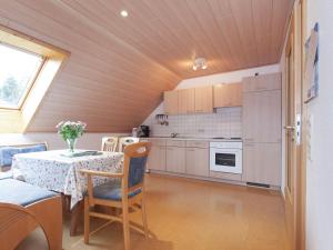 eine Küche mit einem Tisch und einem Esszimmer in der Unterkunft Modern Apartment in Waldachtal near the Forest in Waldachtal