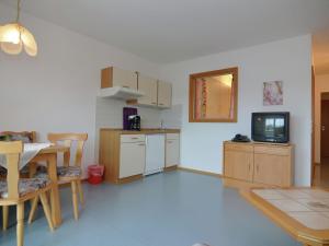 eine Küche mit einem Tisch und einem TV in einem Zimmer in der Unterkunft Apartment in Rotthalm nster with Terrace Garden Parking BBQ in Rotthalmünster