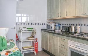 a kitchen with wooden cabinets and a microwave at 4 Bedroom Stunning Apartment In Mlaga in Málaga