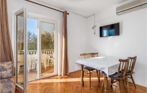 a dining room with a table and a balcony at 2 Bedroom Stunning Apartment In Rab in Rab