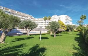 a park with trees and umbrellas in front of a building at Awesome Apartment In Altea With Wifi in Altea +11 photos