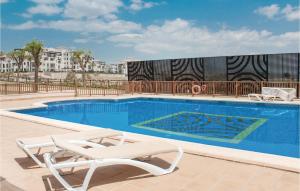 a swimming pool with two lounge chairs next to it at Amazing Apartment In Baños Y Mendigo in Baños y Mendigo