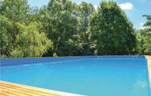uma piscina azul com árvores ao fundo em Beautiful Home In Quiestede With 5 Bedrooms, Wifi And Outdoor Swimming Pool em Quiestède
