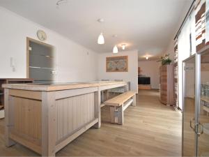 a large kitchen with a wooden counter and a bench at Holiday home with garden near Hammersee in Bodenwöhr