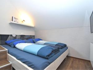 łóżko w pokoju z niebieskimi poduszkami w obiekcie Modern Apartment in V hl near the forest w mieście Vöhl