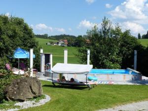 a group of people laying on a raft next to a swimming pool at Spacious apartment near the ski area in Steingaden