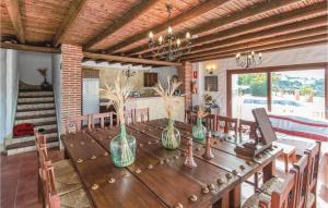 カニージャス・デ・アルバイダにあるAwesome Home In Canillas De Albaida With Jacuzzi, Outdoor Swimming Pool And Swimming Poolの木製テーブル(椅子、花瓶付)