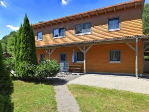 バート・ヴィルドゥンゲンにあるHoliday farm situated next to the Kellerwald Edersee national park with a sunbathing lawnのパティオが目の前にある木造家屋