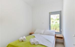 a bedroom with a bed with towels and a window at 2 Bedroom Beautiful Apartment In Pag in Pag