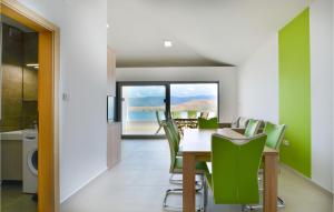 a dining room with a table and green chairs at 2 Bedroom Beautiful Apartment In Pag in Pag