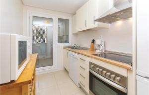 a kitchen with white cabinets and a sink at 2 Bedroom Amazing Apartment In Roldán in Los Tomases