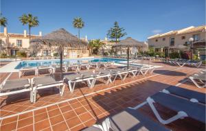 ein Resort mit einem Pool, Stühlen und Palmen in der Unterkunft Awesome Home In Mijas Costa With Wifi in Mijas Costa